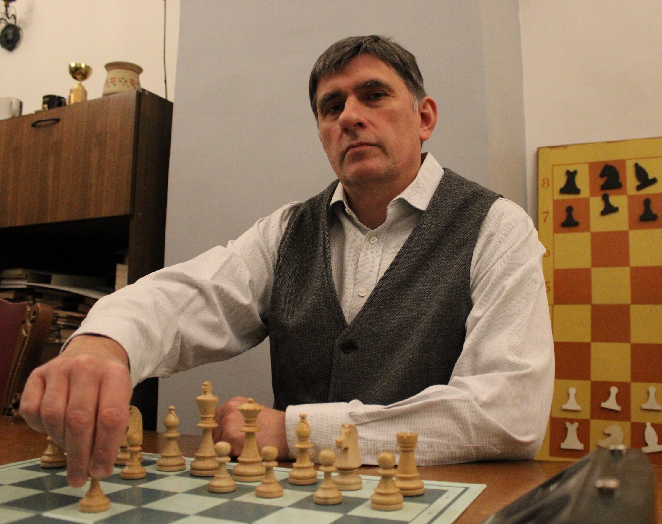Шахматный тренер Михаил Рычагов делает первый ход за шахматной доской